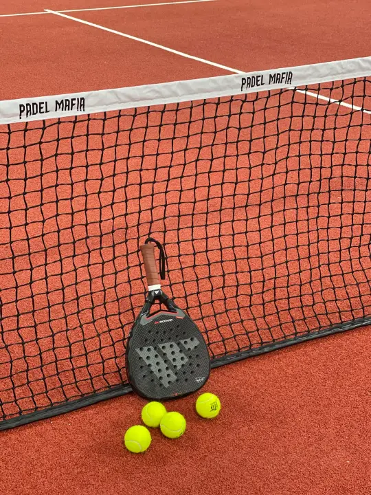 Racket and balls at the Padel Mafia net