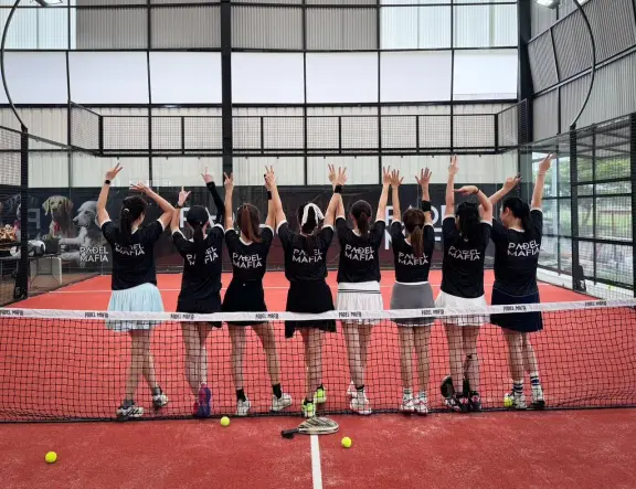 Players celebrating at the net in Padel Mafia shirts